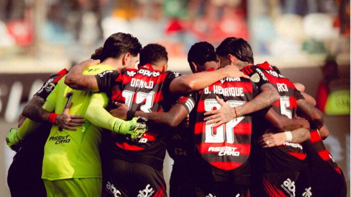 Atletas do Flamengo reunidos em círculo antes da partida contra o Palmeiras