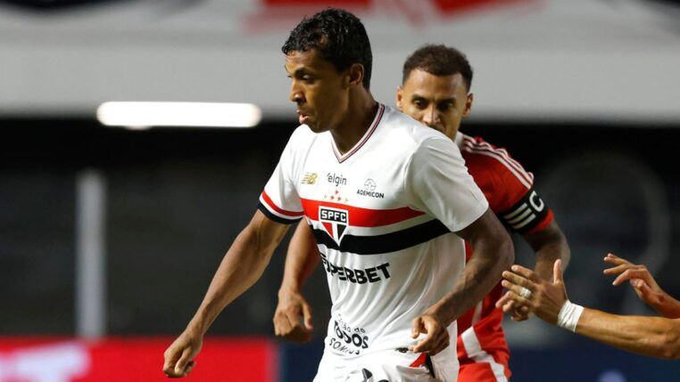 Atleta Luiz Gustavo, do São Paulo, disputando bola com um jogador do Internacional