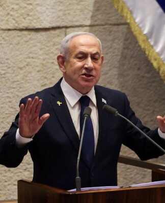 Benjamin Netanyahu falando em palanque com uma bandeira de Israel em cada lado