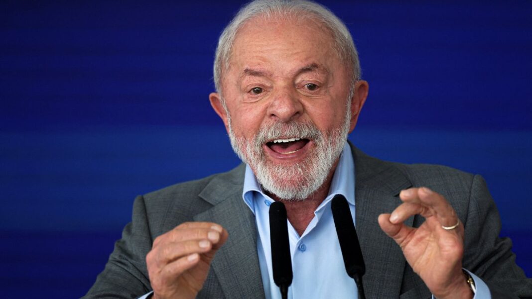Lula gesticula com as duas mãos diante de microfone