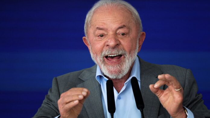 Lula gesticula com as duas mãos diante de microfone