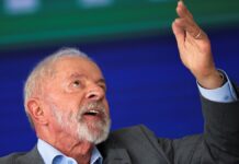 Lula aponta para o alto com a mão esquerda durante discurso