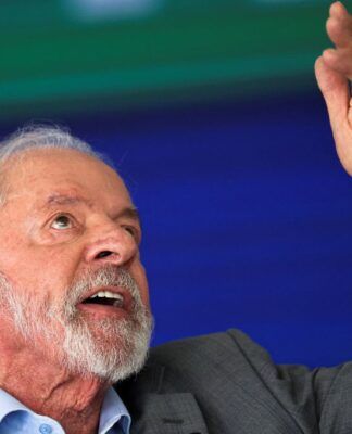 Lula aponta para o alto com a mão esquerda durante discurso