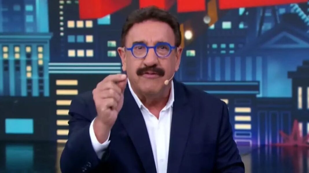 Apresentador Ratinho gesticula ao falar ao microfone