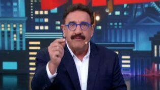 Apresentador Ratinho gesticula ao falar ao microfone