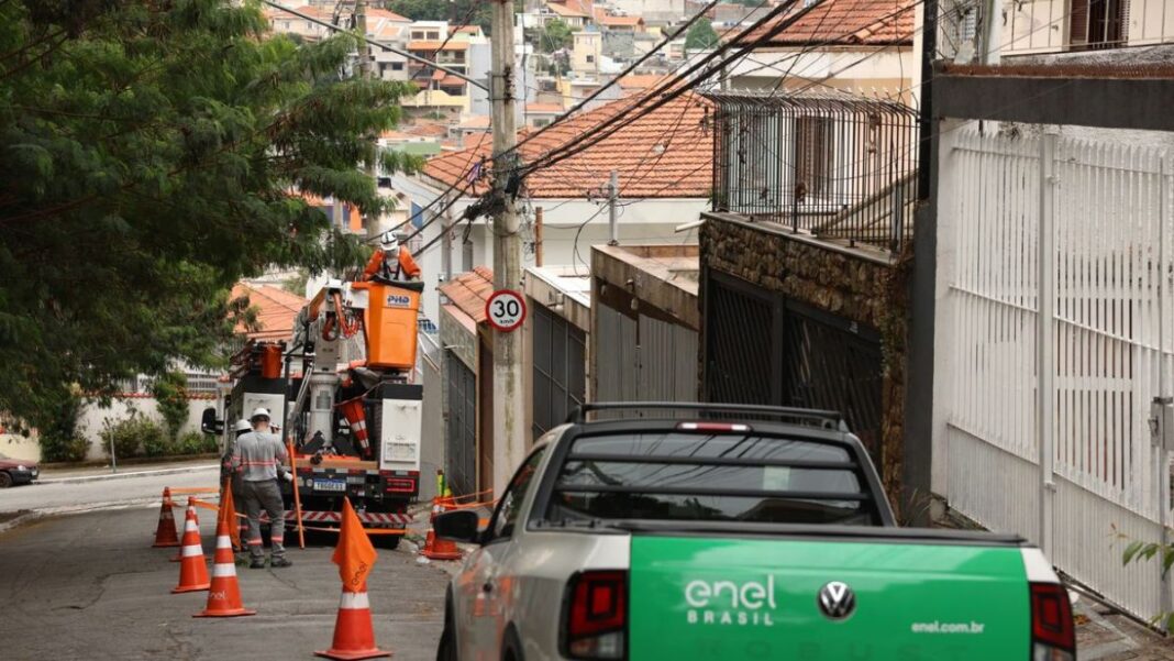 Carro da Enel faz atendimento em poste em rua de São Paulo