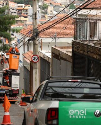 Carro da Enel faz atendimento em poste em rua de São Paulo