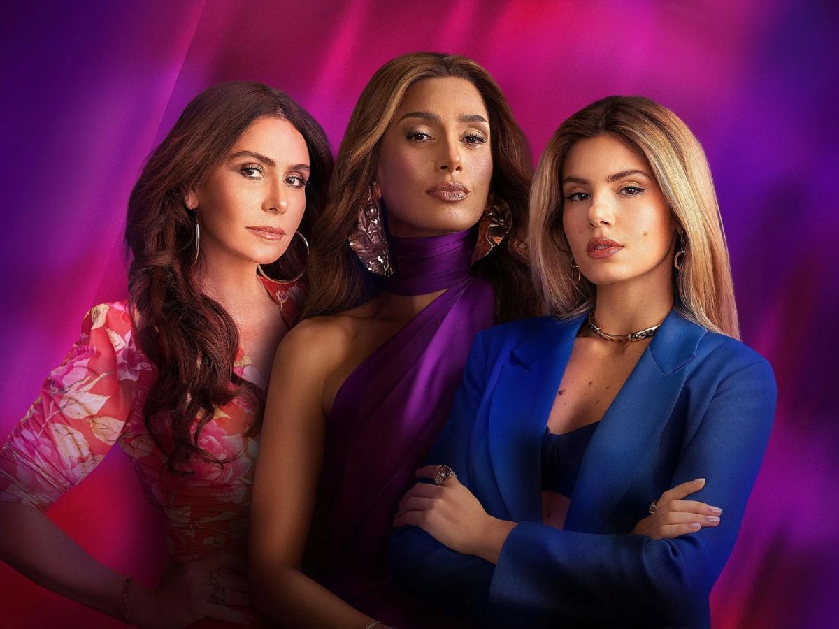 Três mulheres estão lado a lado, todas olhando para frente.