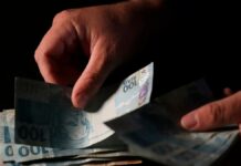 imagem de uma mão manipulando notas de dinheiro