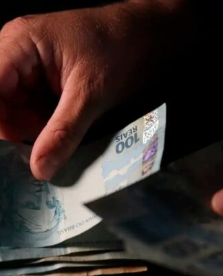 imagem de uma mão manipulando notas de dinheiro