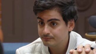 A foto apresenta um primeiro plano (close-up) do rosto de Dudu Camargo, capturado em um ângulo levemente lateral. Ele parece estar em meio a uma conversa ou entrevista em um ambiente interno.