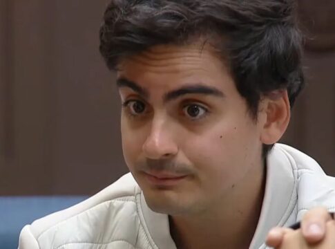 A foto apresenta um primeiro plano (close-up) do rosto de Dudu Camargo, capturado em um ângulo levemente lateral. Ele parece estar em meio a uma conversa ou entrevista em um ambiente interno.