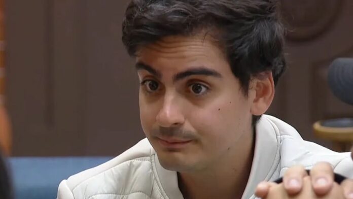 A foto apresenta um primeiro plano (close-up) do rosto de Dudu Camargo, capturado em um ângulo levemente lateral. Ele parece estar em meio a uma conversa ou entrevista em um ambiente interno.