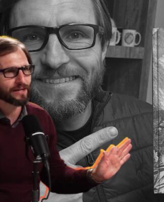 O Dr. Júlio Luchmann aparece do peito para cima, posicionado à esquerda. Ele está em meio a uma fala entusiasmada, com as duas mãos levantadas e as palmas voltadas para a frente, em um gesto de explicação ou ênfase.