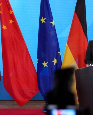 Os ministros das Relações Exteriores da Alemanha e da China, Johann Wadephul e Wang Yi, aparecem em encontro formal, com as bandeiras dos dois países ao fundo.