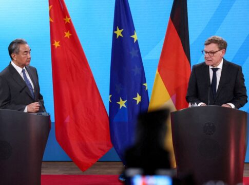 Os ministros das Relações Exteriores da Alemanha e da China, Johann Wadephul e Wang Yi, aparecem em encontro formal, com as bandeiras dos dois países ao fundo.