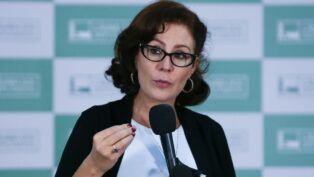 A deputada Carla Zambelli fala ao microfone e gesticula em evento no Congresso