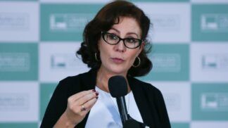 A deputada Carla Zambelli fala ao microfone e gesticula em evento no Congresso