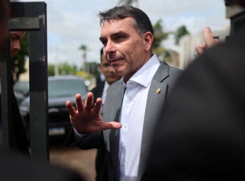 Flávio Bolsonaro faz gesto com a mão ao falar com os jornalistas