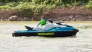 A imagem mostra uma criança muito pequena pilotando um jet ski em um corpo d'água, com o rosto borrado digitalmente para proteger sua identidade, conforme indicado pela nota do Conselho Tutelar sobre o episódio.