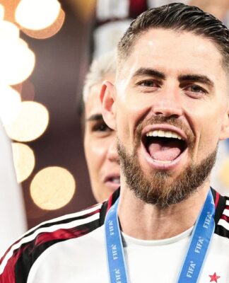 A imagem é um close-up frontal do jogador de futebol Jorge Luiz Frello Filho (Jorginho), meio-campista do Flamengo, em um momento de intensa celebração, após uma vitória na Copa Intercontinental.