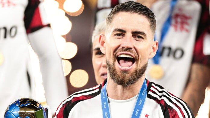 A imagem é um close-up frontal do jogador de futebol Jorge Luiz Frello Filho (Jorginho), meio-campista do Flamengo, em um momento de intensa celebração, após uma vitória na Copa Intercontinental.