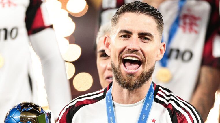 A imagem é um close-up frontal do jogador de futebol Jorge Luiz Frello Filho (Jorginho), meio-campista do Flamengo, em um momento de intensa celebração, após uma vitória na Copa Intercontinental.