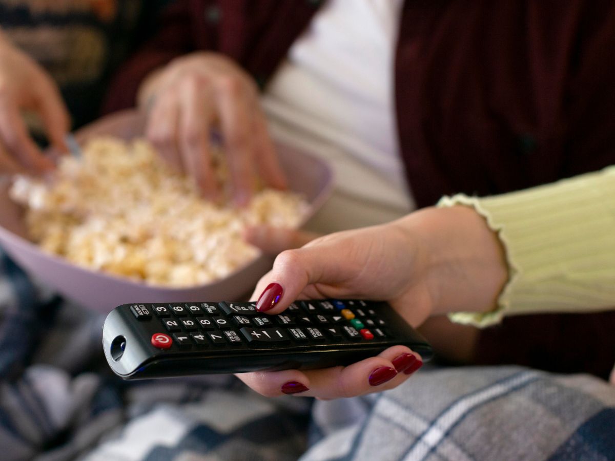 Imagem ilustrativa de alguém segurando controle de tv