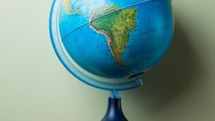 livros empilhados e um globo terrestre no topo