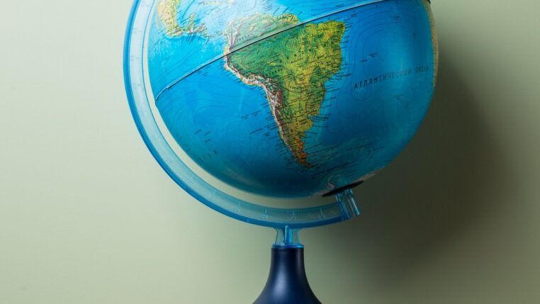 livros empilhados e um globo terrestre no topo