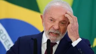 A foto é um primeiro plano (close-up) do presidente Lula, capturado do peito para cima, enquanto ele realiza um pronunciamento. Ele está centralizado e voltado ligeiramente para a direita.