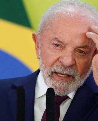 A foto é um primeiro plano (close-up) do presidente Lula, capturado do peito para cima, enquanto ele realiza um pronunciamento. Ele está centralizado e voltado ligeiramente para a direita.