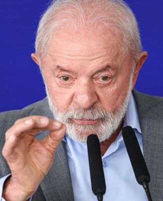 A imagem é um close-up que foca no rosto e na parte superior do tronco do presidente Luiz Inácio Lula da Silva, que está falando ou fazendo um pronunciamento.