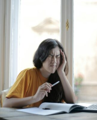 Mulher sentada com a mão no rosto