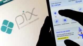 Imagem mostra a silhueta de uma mão segurando um celular e mexendo num aplicativo de banco. Atrás, aparece um fundo desfocado com a palavra "Pix" em destaque.