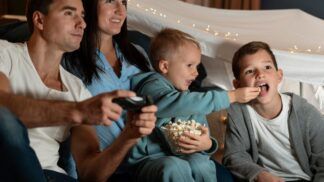 Em imagem ilustrativas família está pronta para assistir um filme em casa