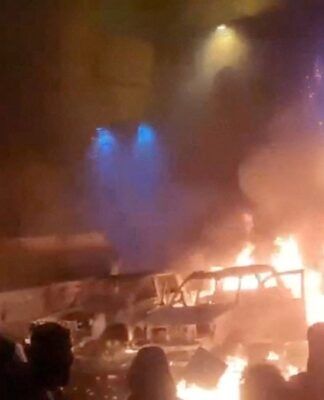 Manifestantes se reúnem enquanto veículos queimam em meio ao avanço dos protestos contra o governo iraniano, em Teerã