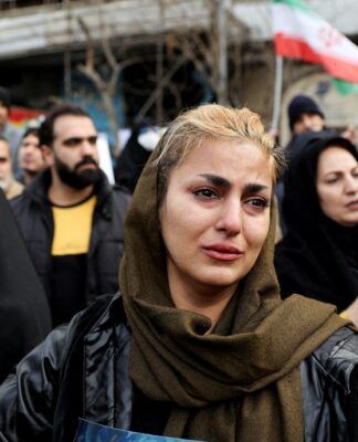 Mulher iraniana reage durante o funeral de integrantes das forças de segurança mortos nos protestos desencadeados pelo colapso do valor da moeda