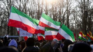 Manifestantes seguram bandeiras durante uma marcha em apoio aos protestos em todo o Irã, em Berlim, na Alemanha