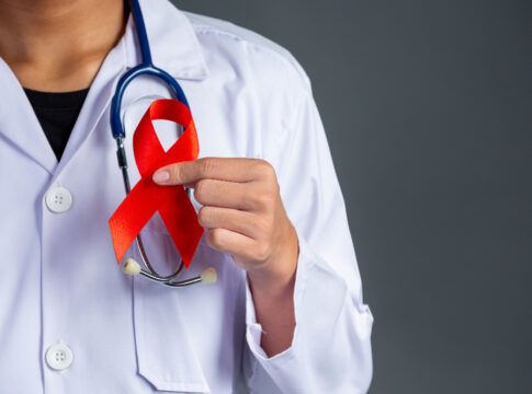 O médico segura um laço vermelho, símbolo da conscientização sobre o HIV, do Dia Mundial de Luta contra a Aids e do Dia Mundial da Saúde Sexual