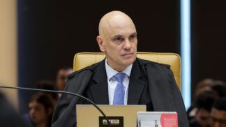 Alexandre de Moraes sentado em sua cadeira do STF