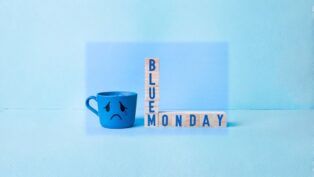 Imagem conceitual de Blue Monday, com caneca azul com cara triste e brinquedo de montar formando a palavra