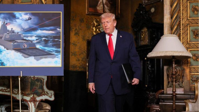 O presidente dos Estados Unidos, Donald Trump, passa por uma imagem de projeção do navio da “Classe Trump”, o USS Deifant, em Mar-a-Lago, em Palm Beach, na Flórida
