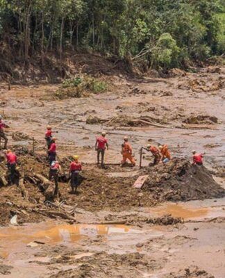 Homens tentam resgatar corpos no meio da lama