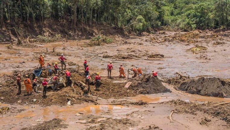 Homens tentam resgatar corpos no meio da lama