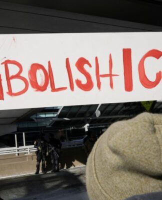 Pessoa segura um cartaz escrito: 