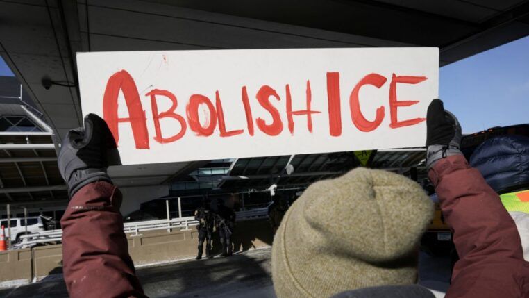 Pessoa segura um cartaz escrito: "Abolish ICE"