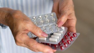 Mulher idosa segura cartela de remédio