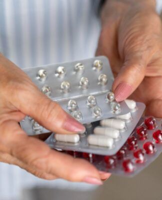 Mulher idosa segura cartela de remédio