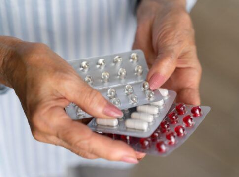 Mulher idosa segura cartela de remédio